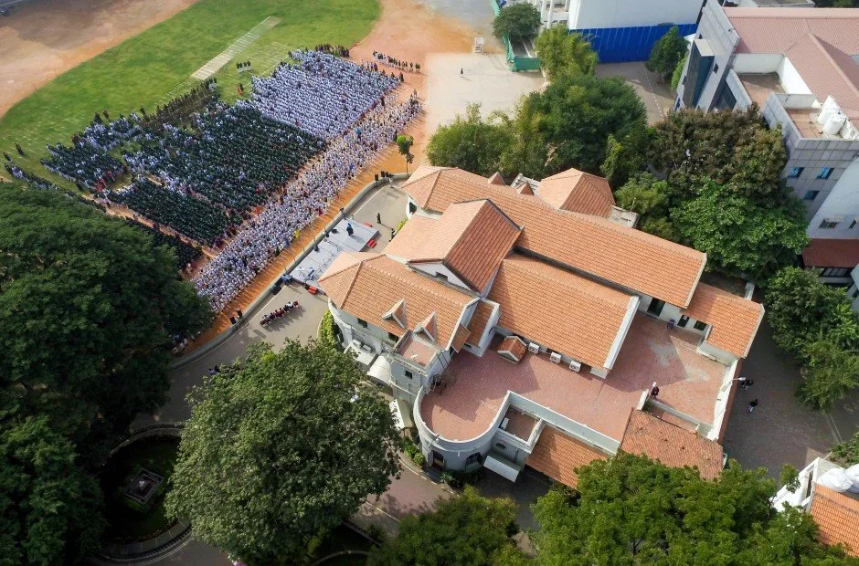Aerial view of the school campus, building and morning assembly on the grounds